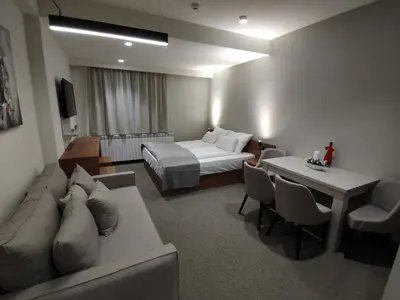 a hotel room with a bed and a couch and a table at Star Hill - Koznik Konaci in Kopaonik