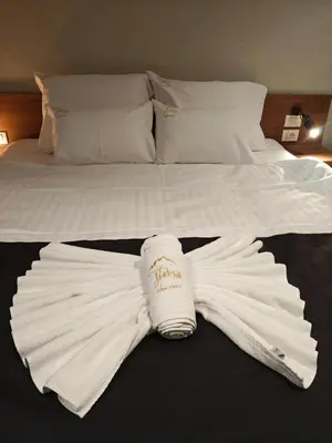 a white robe laying on top of a bed at Star Hill - Koznik Konaci in Kopaonik