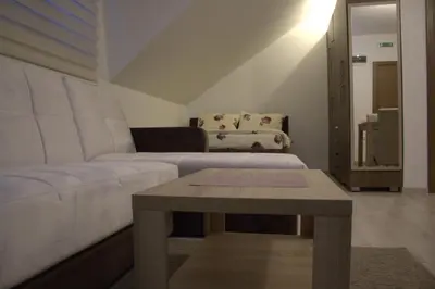 a living room with a white couch and a table at Kraljev Konak in Kopaonik