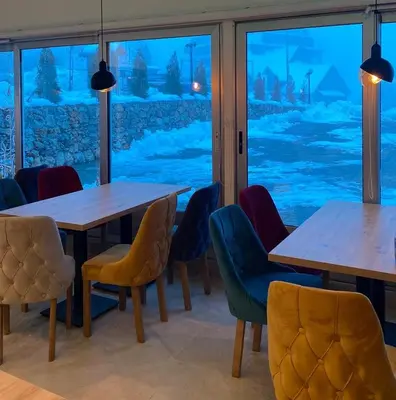 a room with tables and chairs and a window at Kraljev Konak in Kopaonik