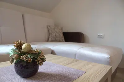 a living room with a couch and a vase on a table at Kraljev Konak in Kopaonik