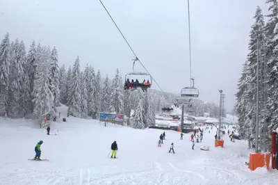 a group of people on a ski lift in the snow at Kraljev Konak in Kopaonik