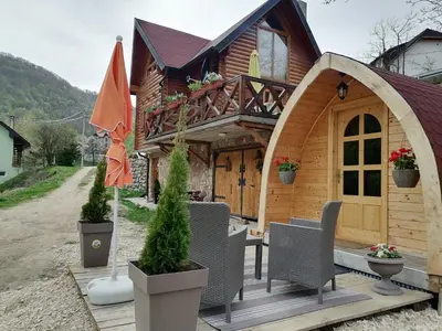 a house with a gazebo and chairs in front of it at Vila Jelena - BUNGALOV in Crni Vrh