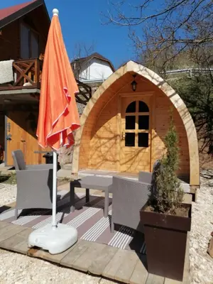 an orange umbrella and a table and a chair and a house at Vila Jelena - BUNGALOV in Crni Vrh