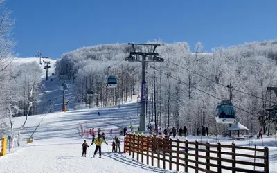 a group of people on a ski slope with a ski lift at Vila Jelena - BUNGALOV in Crni Vrh