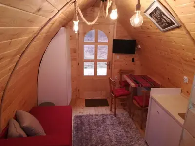 a room in a tiny house with a red couch at Vila Jelena - BUNGALOV in Crni Vrh