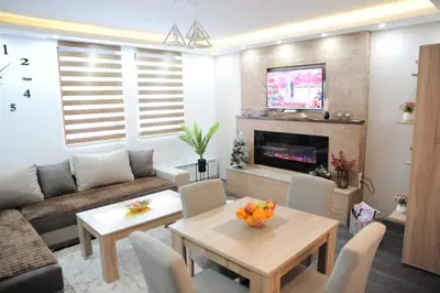 a living room with a couch and a table at Apartman Kalina Suncani Breg in Kopaonik