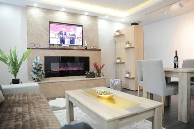 a living room with a tv above a fireplace at Apartman Kalina Suncani Breg in Kopaonik