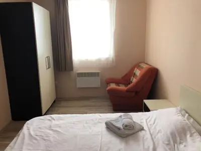 a bedroom with a bed and a chair and a window at Jolly Kop, Villa Jovana, apartman 18 in Kopaonik
