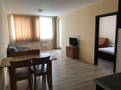 a living room with a table and a bed and a mirror at Jolly Kop, Villa Jovana, apartman 18 in Kopaonik