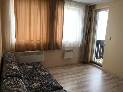 a living room with a couch in front of a window at Jolly Kop, Villa Jovana, apartman 18 in Kopaonik