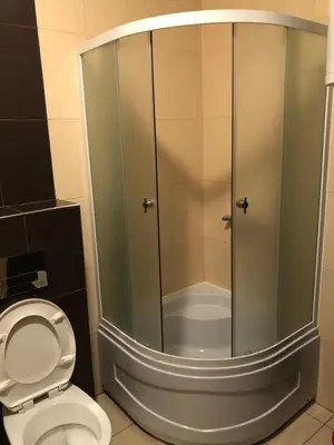 a glass shower in a bathroom with a toilet at Jolly Kop, Villa Jovana, apartman 18 in Kopaonik