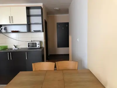 a kitchen with a table and two chairs and a microwave at Jolly Kop, Villa Jovana, apartman 18 in Kopaonik