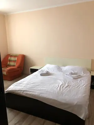a bedroom with a bed and an orange chair at Jolly Kop, Villa Jovana, apartman 18 in Kopaonik