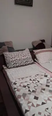 two beds sitting next to each other in a bedroom at Snezana home in Vranje