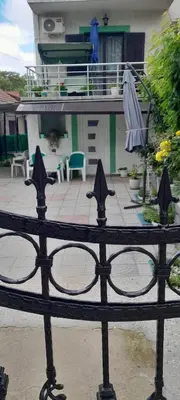 a black fence with an umbrella and a patio at Snezana home in Vranje