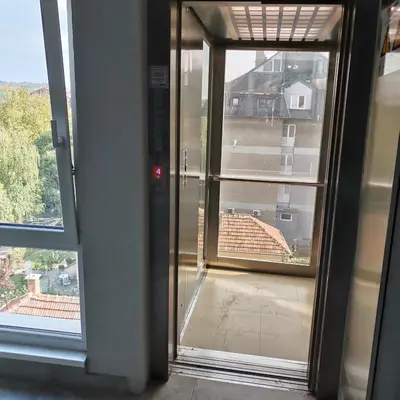 an open glass door with a view of a building at Apartman Lea & parking u garaži in Soko Banja