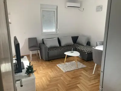 a living room with a couch and a table at Vrnjačka Banja Apartman in Vrnjačka Banja