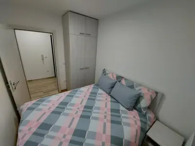 a bedroom with a checkered bed and a mirror at Vrnjačka Banja Apartman in Vrnjačka Banja