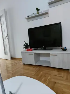 a living room with a flat screen tv on a entertainment center at Vrnjačka Banja Apartman in Vrnjačka Banja