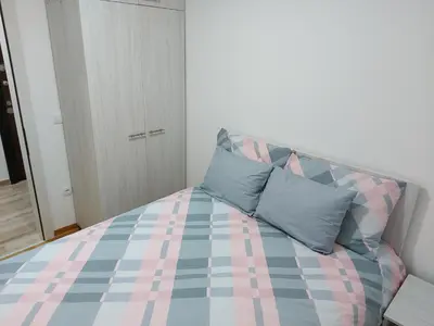 a bedroom with a bed with blue and pink at Vrnjačka Banja Apartman in Vrnjačka Banja