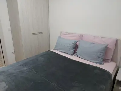 a bed with two blue pillows on top of it at Vrnjačka Banja Apartman in Vrnjačka Banja