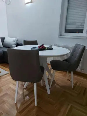 a white table and chairs in a living room at Vrnjačka Banja Apartman in Vrnjačka Banja