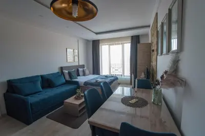 a living room with a blue couch and a table at Apartman Klara S 23 in Kopaonik