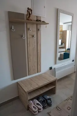 a mirror and a wooden bench in a room at Apartman Klara S 23 in Kopaonik