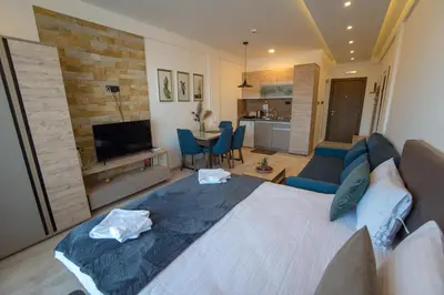 a bedroom with a large bed and a living room at Apartman Klara S 23 in Kopaonik