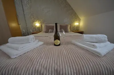 a hotel room with two beds with towels and a bottle of wine at Lužnjanin restoran i sobe in Jošanička Banja