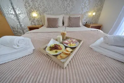 a tray with a plate of food on a bed at Lužnjanin restoran i sobe in Jošanička Banja