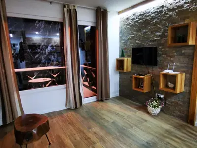 a living room with a television and a table and a chair at Soko lux apartman in Kopaonik