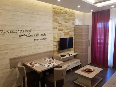 a living room with a table and a tv at Apartman K5 Milmari Resort in Kopaonik