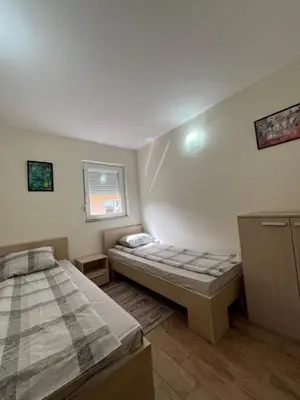 two twin beds in a room with a window at Apartmani Radoičić in Jošanička Banja