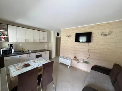 a kitchen with a table and a tv on the wall at Apartmani Radoičić in Jošanička Banja