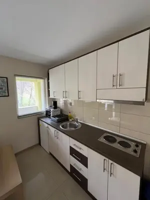 a kitchen with white cabinets and a sink at Apartmani Radoičić in Jošanička Banja