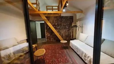 a living room with a white couch and a staircase at Dom sa pogledom Jela in Jelašnica