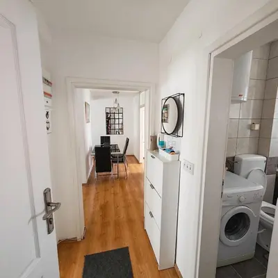 a white room with a washing machine and a kitchen at Apartman - stan na dan LENJINKA in Vranje
