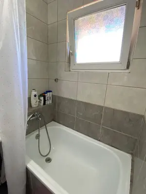 a bathroom with a bath tub and a window at Apartman - stan na dan LENJINKA in Vranje