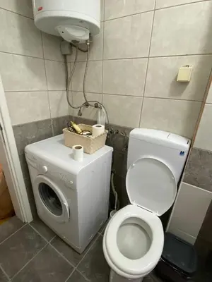 a bathroom with a toilet and a washing machine at Apartman - stan na dan LENJINKA in Vranje