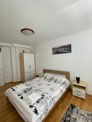 a bedroom with a bed with a black and white blanket at Apartman - stan na dan LENJINKA in Vranje