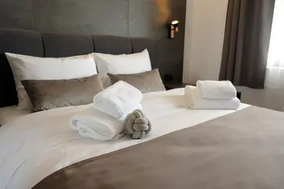a white bed with towels and a teddy bear on it at Vila Planinsko Blago in Kopaonik
