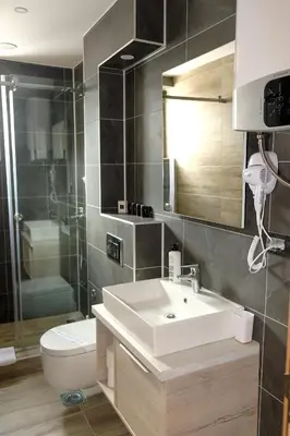 a bathroom with a sink and a toilet and a mirror at Vila Planinsko Blago in Kopaonik