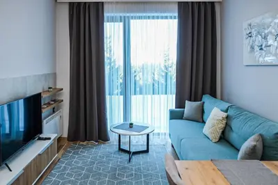 a living room with a blue couch and a tv at Vila Planinsko Blago in Kopaonik