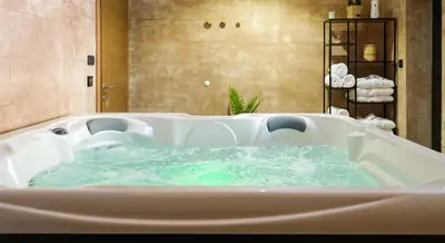 a bath tub filled with water in a bathroom at Vila Planinsko Blago in Kopaonik