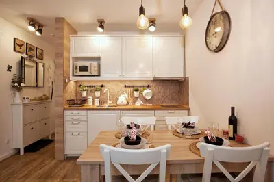 a kitchen with a wooden table and white cabinets at Dream View Apartment in Kopaonik