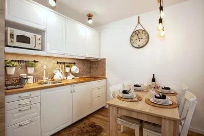 a kitchen with a table and a clock on the wall at Dream View Apartment in Kopaonik