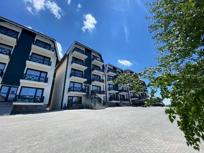 a row of apartment buildings in a parking lot at Dream View Apartment in Kopaonik