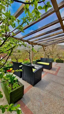 a patio with a table and chairs under a pergola at Vila Djordjevic - Priroda vas okruzuje in Brus